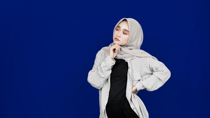 asian hijab woman thingking and get idea isolated blue background
