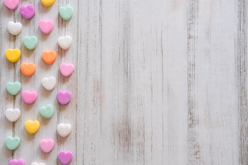 Flat lay Candy Hearts Pattern - Pastel rainbow conversation heart candy design for Valentine's Day. Top view sweet decor for Easter.