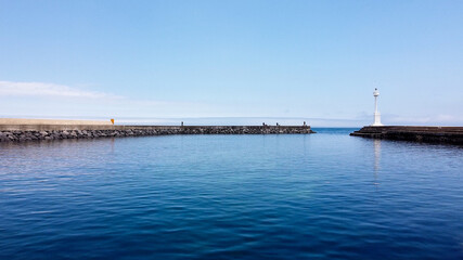 Obraz premium White lighthouse and calm sea photo