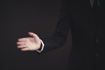 Businessman in black suit open hand for shaking hands.