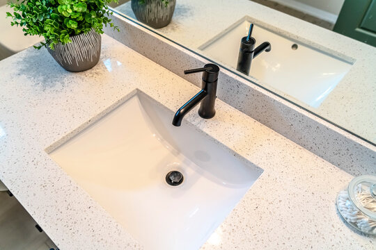 Top View Of Sink And Black Faucet Fixed On The White Countertop Of A Bathroom