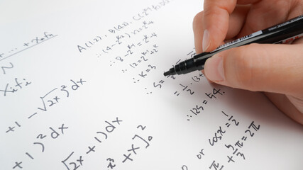 Handwriting to solve math formulas holding a computer pen. Math Formulas solves the test, practice, test or exam, background concept in math class.