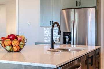 Kitchen island with black curved faucet and stainless steel double bowl sink