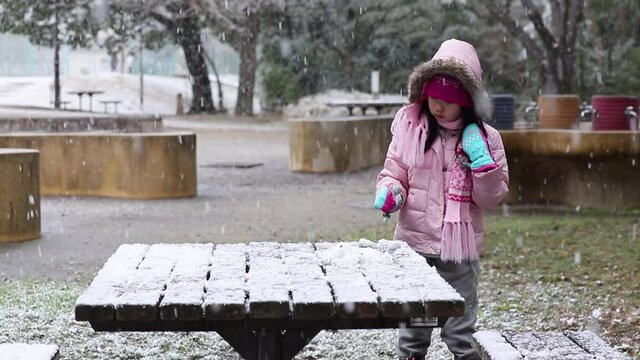 冬の公園で雪遊びしている可愛い子供