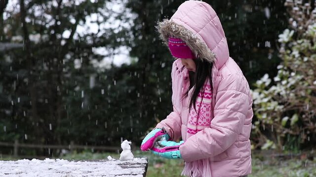 冬の公園で雪遊びしている可愛い子供