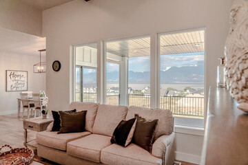 Living room interior with comfortable couch and view of scenic lake and mountain