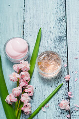 cosmetic creams with pink hyacinth flowers, on old cracked blue table