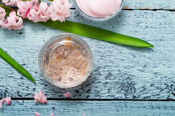 cosmetic creams with pink hyacinth flowers, on old cracked blue table