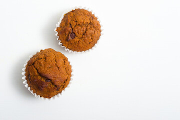 pair of chocolate muffins on white table