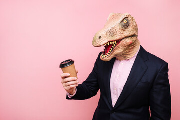 Lizard-headed man holding a recyclable cardboard cup of coffee.