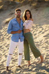 Young couple standing on the sand of the beach