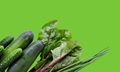 Frame of Green vegetables like cucumber, zucchini, leaves at green background isolated. Copyspace