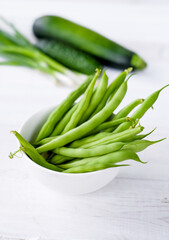The green beans in white plate with green vegetables
