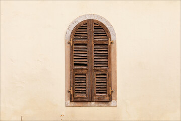 Caratteristica vecchia finestra chiusa con falegnameria in legno marrone. Facciata di edificio storico nel centro della città.