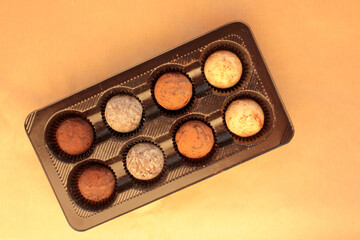 Chocolate truffles in box on a craft paper background. View from overhead