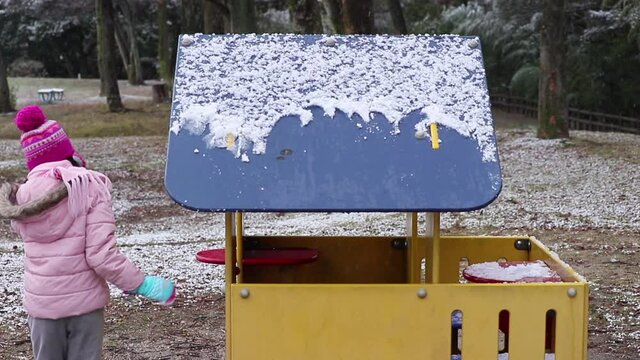 冬の公園の小屋で雪遊びしている可愛い子供