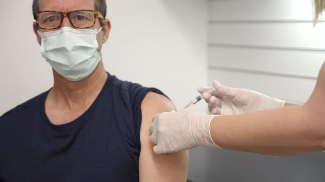 a male patient receives a vaccination in their arm