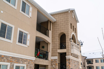 Three storey apartment with balconies and metal railings on the upper floors