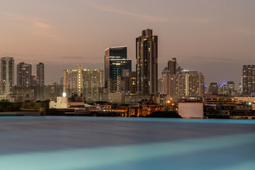 Bangkok, thailand - Dec 30, 2020 : Silhouette of Bangkok city skylines with light reflection in swimming pool during sunset. Selective focus