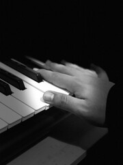 hands playing piano black and white