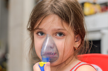 Little girl child makes inhalation with mask on face	
