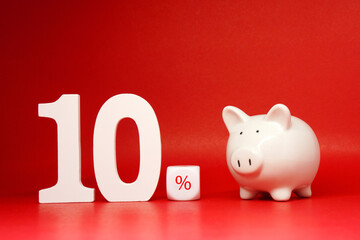 Ten ( 10 ) Percentage word with piggy bank Isolated on Red Background with Copy Space , Saving money 10% , Bank and Business finance promotion Concept - Creative