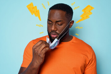 Boy is tired to breathe through the mask. cyan background