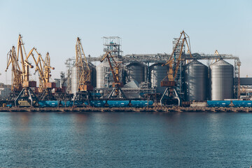 Fototapeta na wymiar Yellow loading crane. Black Sea commercial port, container loading by crane. Shipping. Container import and export logistics, cargo harbor view. Panorama of harbor cranes.