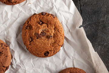 Chocolate cookies on white torn paper.
