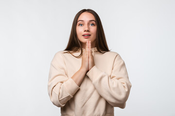 Image of pleased brunette woman with long hair smiling and holding palms together
