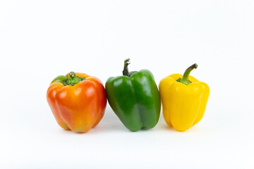 Fresh vegetables, juicy red, yellow, green peppers with a green stem stands on an isolated white background. Fresh vegetables.