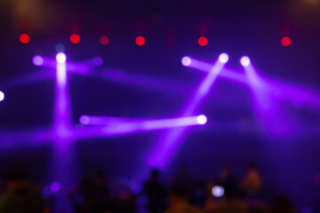 Fototapeta na wymiar Abstract blurred photo of spotlight on the stage in conference hall or nightclub, silhouette audience or customer in restaurant,seminar and party environment,happy new year and merry christmas concept