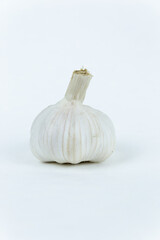 Garlic lies on an isolated white background. Fresh vegetables. White head of garlic lies on an isolated white background