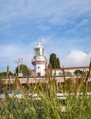 Sochi, Russia - November 23, 2020: Main city lighthouse built in late 1800s on Primorskaya embankment. Close-up. Lighthouse on  background of blue sky with white clouds.