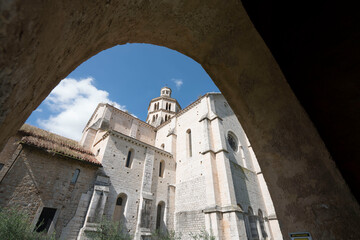 Inquadratura suggestiva di abbazia medioevale vista dal basso verso l'alto incorniciata da un arco in primo piano