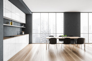 White and grey minimalist kitchen with chairs and table near window