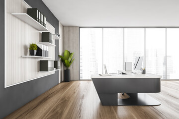 Wooden and black office room with table and computer, plant and window