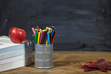 red apple, books, red leaves and penciles on wooden table and blackdoard background.school for kids. - 402801450