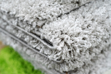 Large pile synthetic material rugs. Trade in textiles in a store. Close-up