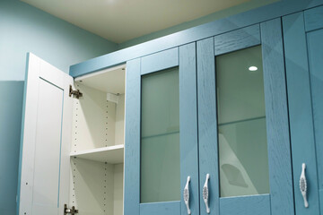 A fragment of a blue kitchen set with an open door. Cropped frame. Close-up