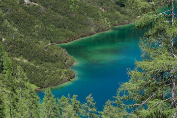 Fototapeta na wymiar green blue lake in the green nature while hiking in the mountains