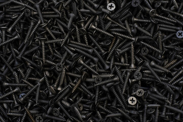 Lots of black self-tapping screws. Beautiful metallic background in dark colors. Flat lay of the frame. Template for the designer