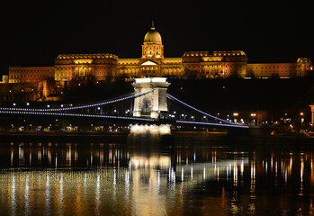 Fototapeta na wymiar Night Budapest, Chain bridge on the background of Buda Castle, reflection of night lights on the water