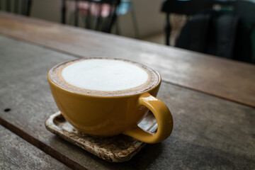 Hot latte art coffee in cup on wooden table