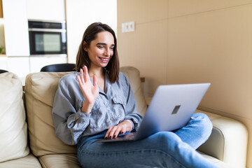 Young happy woman holding video call, gesturing hi to friends, relatives or parents. Attractive female blogger recording new video to followers.