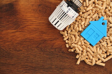 an old oak board with wood pellets and a radiator thermostat