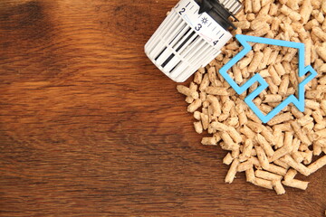 an old oak board with wood pellets and a radiator thermostat