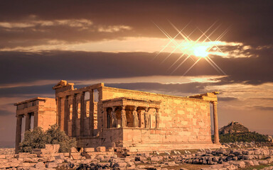 Erechtheion ancient temple with Caryatids statues on Acropolis illuminated by dramatic, fiery sunny sky, Athens Greece