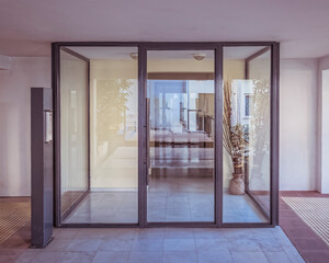 modern apartment building entrance glass and metal door, central perspective