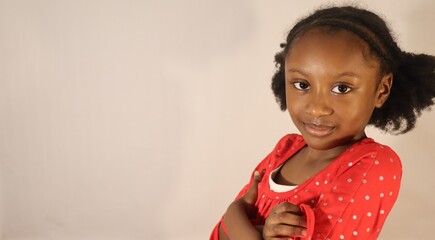 Small African American Girl posing with arms cross closed up indoors white background horizontal banner